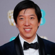 Dan Lin in a tux on a red carpet